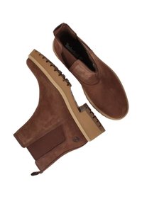 Bruine suède enkellaarzen met elastische zijpanelen, textuurdetails, rubberen zolen en een Timberland-logo aan de zijkant.