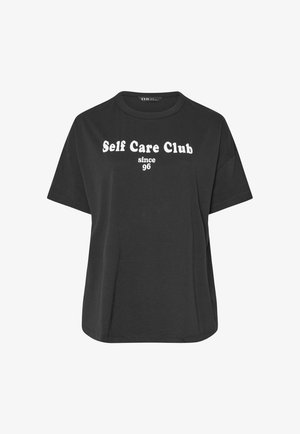 Zwart T-shirt met korte mouwen en witte tekst "Self Care Club since 96" gecentreerd op de borst, ronde halslijn en losse pasvorm.