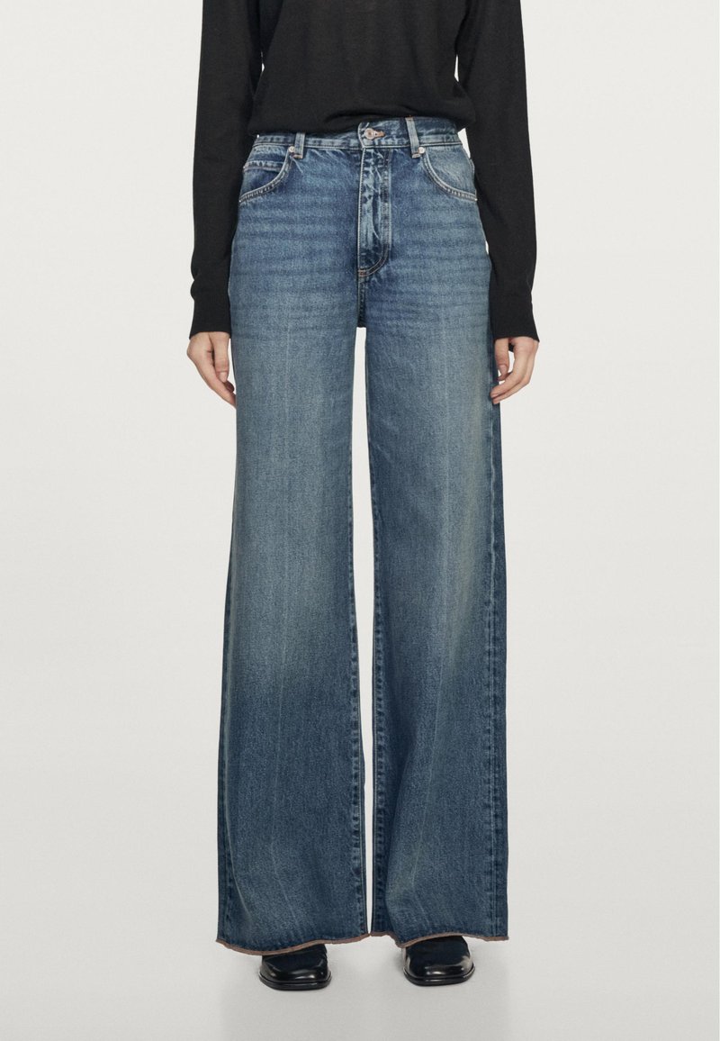 Jeans o szerokich nogawkach w średnim niebieskim odcieniu, z wysokim stanem, kieszeniami z przodu i postrzępionymi brzegami dla dodatkowej tekstury.