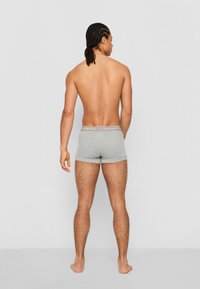 Graue Baumwoll-Boxershorts mit einem logoakzentuierten Bund, die eine enge Passform und eine weiche Textur aufweisen, von hinten auf einem neutralen Hintergrund betrachtet.