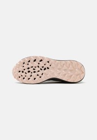 Suola di scarpa atletica nera con fondo in gomma rosa testurizzata, caratterizzata da un motivo robusto di tappi ovali e triangolari per trazione.