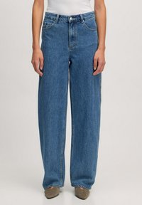 Jeans en denim bleus clairs à jambes larges, avec une taille haute, un design à cinq poches et une fermeture à bouton et éclair. Texture lisse.