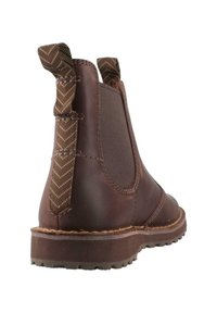 Botín de cuero marrón con paneles laterales elásticos, tiradores decorativos y suela de goma texturada. Acentos cosidos a lo largo de los bordes.