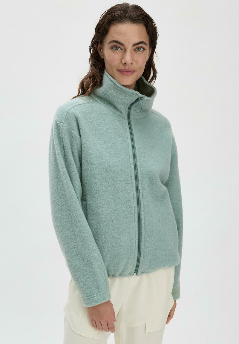 Himmelblaues Fleece-Jacke mit hohem Kragen, Frontreißverschluss und langen Ärmeln. Weicher Stoff und lockere Passform. Minimalistisches Design ohne Muster.
