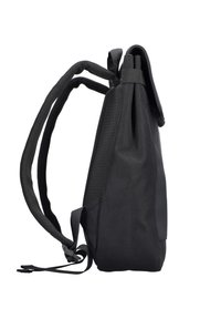 Un sac à dos noir avec des bretelles rembourrées et un rabat supérieur, vu de côté sur un fond blanc.