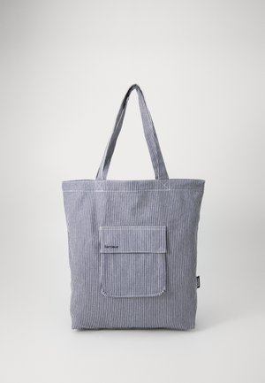 Gestreepte stoffen schoudertas met twee lange handvatten, een voorzak en een topstiklijn detail. Kleuren zijn marineblauw en wit.