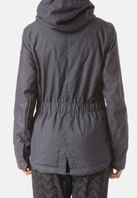 Tmavě šedá kapucí ozdobená bunda s taženým pasem, vybavená zadním rozparkem a manžetami na knoflíky. Vyrobená z texturované látky s volným střihem.