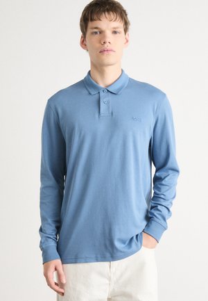 Long-sleeve polo shirt in light blue fabric, featuring a three-button placket and subtle logo on the left chest area. Smooth texture.