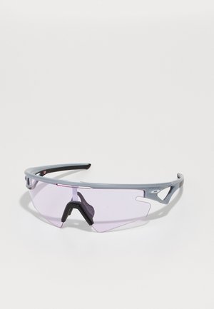Sportsonnenbrille mit grauem Rahmen, lila getönten Gläsern und schwarzer Nasenauflage. Verfügt über ein schlankes Design und Ausschnitten an den Seiten.