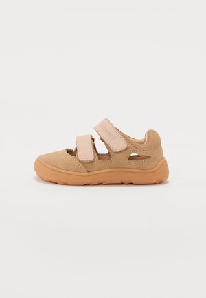 Beige børnesandal med to justerbare velcroremme og gummisål, designet til komfort og nem påtagning.