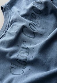 Niebieska bawełniana bluza z podniesionym napisem "Classic Collection" w ciemnym niebieskim kolorze. Żebrowany dekolt oraz miękka tekstura. Minimalistyczny design.