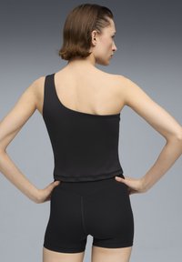 Zwarte een-schouder bodysuit met een gladde textuur, gecombineerd met hoge zwarte shorts, die schone lijnen en een getailleerd ontwerp hebben.