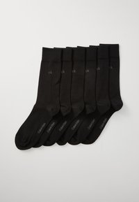Sechs Paar schwarze Calvin Klein Crew-Socken ordentlich auf einem weißen Hintergrund angeordnet, jeweils mit "ck" nahe dem Bündchen und "Calvin Klein" auf dem Fuß.