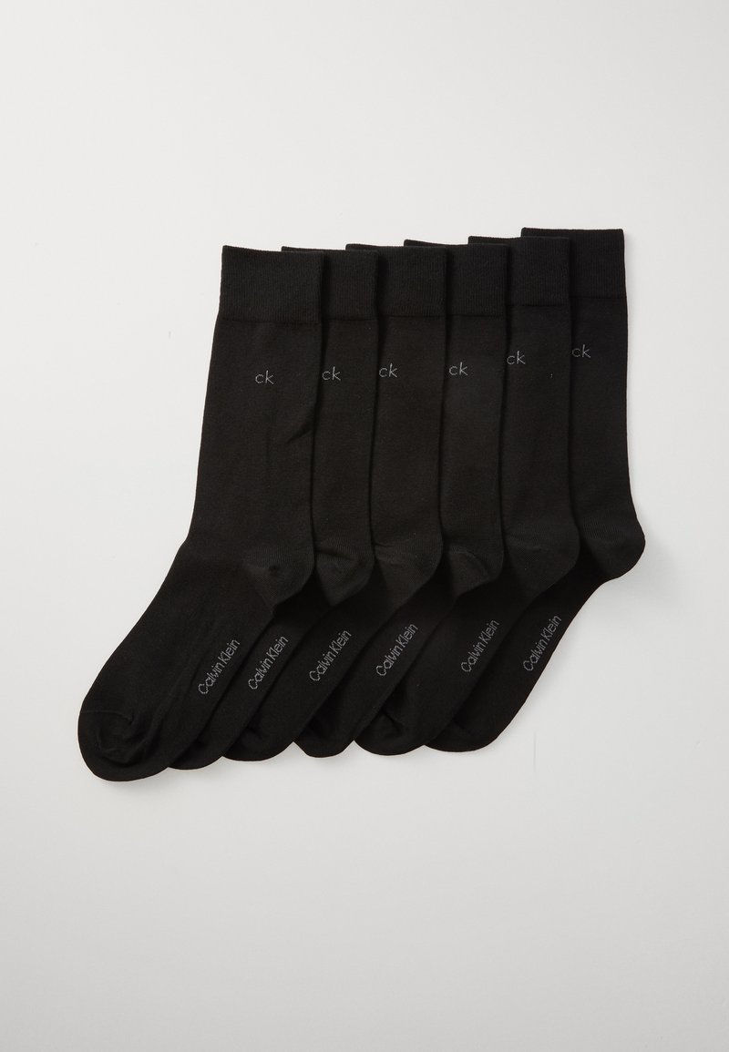 Sechs Paar schwarze Calvin Klein Crew-Socken ordentlich auf einem weißen Hintergrund angeordnet, jeweils mit "ck" nahe dem Bündchen und "Calvin Klein" auf dem Fuß.
