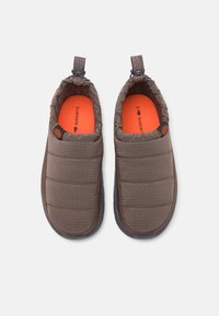 Bruna vadderade tofflor med en texturerad yta, orange innersulor och en svart gummisula. Har en dragflik och snörning för justerbar passform.