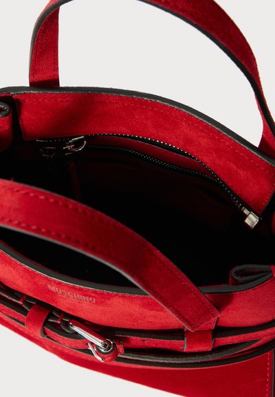 Röd mockaväskan med en kontrasterande svart dragkedja, mjukt inre, dubbla handtag och en silverfärgad detalj.