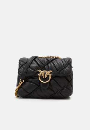 Sac à main en cuir matelassé noir orné d'un embellissement en métal doré avec des motifs d'oiseaux et une bandoulière chaîne.