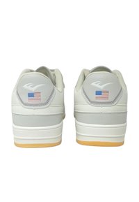 Sneakers bianchi con accenti grigi, suola in gomma, tacco arrotondato e piccolo emblema della bandiera americana vicino alla parte posteriore. Materiale in pelle testurizzata.