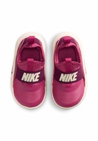 Różowe buty Nike z teksturowaną cholewką, elastycznym paskiem z logo oraz jasnymi podeszwami. Projekt zawiera pętelkę dla łatwego zakładania.