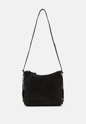 Schwarze Leder-Umhängetasche mit geschwungenem Design, verstellbarem Riemen, Reißverschluss und minimalen Nähten an den Seiten.