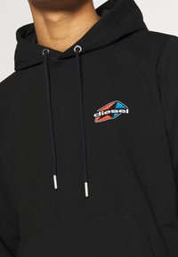 Felpa nera con cappuccio e tasca frontale, caratterizzata da un logo Diesel multicolore sul lato sinistro del petto e lacci con punte argentate.