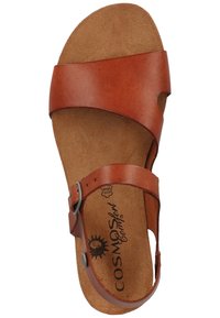 Sandal in pelle marrone con una fascia larga sopra il piede e una fibbia regolabile. Soletta morbida color cammello con logo e design del fondo sagomato.