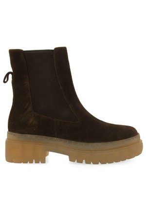 Botín de ante marrón con suela gruesa y transparente, panel elástico lateral para facilitarel calzado y una lengüeta en la parte trasera para mayor accesibilidad.