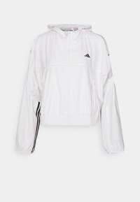 Veste de sport blanche à capuche avec fermeture éclair à l'avant, taille élastique, poches zippées, logo Adidas noir sur la poitrine et bandes noires sur les manches.