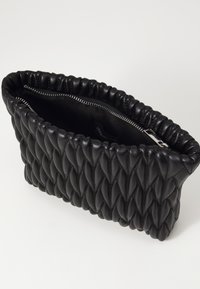 Black leather clutch bag with quilted diamond pattern and gathered edge. Features a zip closure and a smooth, matte texture.