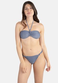 Ensemble bikini en tissu bleu texturé. Haut bandeau avec détail de nœud à l'avant et lien à nouer autour du cou. Bas avec un design à nœud latéral.