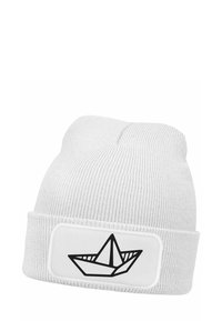 White knit beanie with a folded cuff, featuring a black line drawing of a paper boat on a white patch. Soft texture, ribbed design.