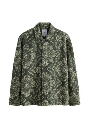Green patterned jacket featuring large cream floral designs, button-up front, and a pointed collar, made from textured fabric.