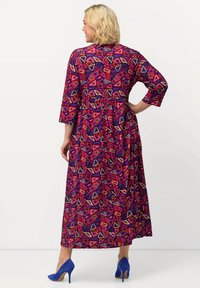 Bunt gemustertes Maxikleid mit geometrischem Muster in Rosa-, Lila- und Beigetönen, mit Dreiviertelärmeln und tailliertem Schnitt.