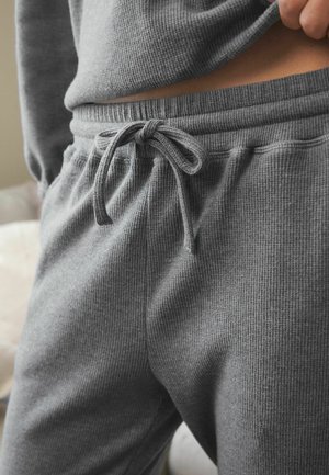 I pantaloni jogger grigi in misto cotone presentano un tessuto a coste testurizzato, una vita elasticizzata con cordino e tasche laterali.