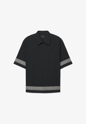 Schwarzes kurzärmeliges Hemd zum Knöpfen mit weißen horizontalen Streifendetails an Ärmeln und Saum, ausgestattet mit einem klassischen Kragen und einer lockeren Passform.