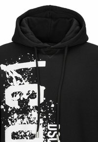 Sweat à capuche noir avec un design graphique blanc comprenant des effets d'éclaboussures et du texte. Le tissu est doux avec un intérieur texturé et une capuche à cordon.