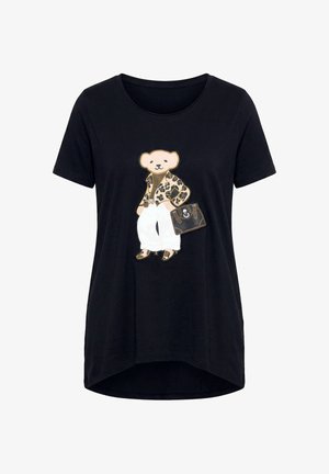 Zwart T-shirt met korte mouwen met een teddybeer die een jas met luipaardprint draagt, witte broek, bruine schoenen en een bruine handtas vasthoudt.