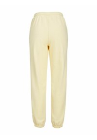 Pantalones deportivos suaves de color amarillo con una cintura y puños elásticos, detallados con una textura lisa y un diseño de pierna recta.