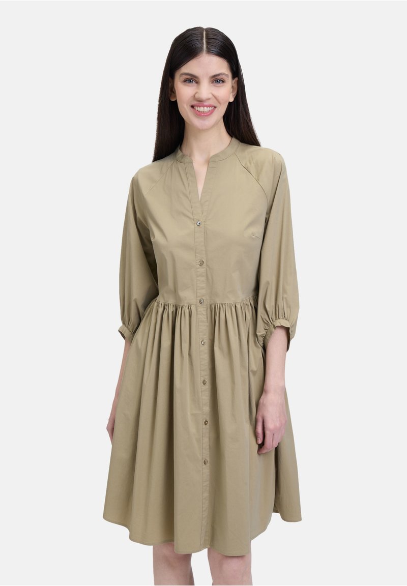 Khakifarbendes Hemdblusenkleid mit einer durchgehenden Knopfleiste, Stehkragen und dreiviertellangen Puffärmeln; geraffte Taille und glatte Textur.