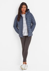 Navy puffer jacket with a hood, quilted design, and front pockets, paired with gray leggings and white sneakers, inner striped top.