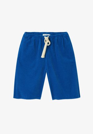 Sinised korduroost lühikesed püksid elastse vöökohaga ja kreemika paelaga. Omavad vertikaalset soonilist tekstuuri ja sirget lõiget, põlveni ulatuvat disaini.