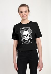 Schwarzes Baumwoll-T-Shirt mit weißem Grafikdruck eines Schädels und gekreuzten Schlägern, mit dem Text "CENTRE COURT RACKET CLUB."