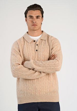 Beige kabelgebreide trui met een kraagnek, drie zwarte knopen en geribde manchetten, met een relaxte pasvorm en een textuurstof.