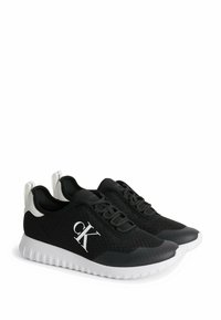 Svarta stickade sneakers med en vit gummisula, med en logotyp på sidan och en kontrasterande hälla. Designade för komfort och avslappnad användning.