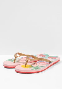 Rosa flip-flops med ett mönstrat fotbed som pryds av tropiska blad och flamingos. Guldremmar med rundade ändar. Gummisula med röda detaljer.