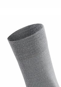 Calzino grigio con polsino a coste, texture liscia e forma aderente. Il materiale appare elastico e traspirante.