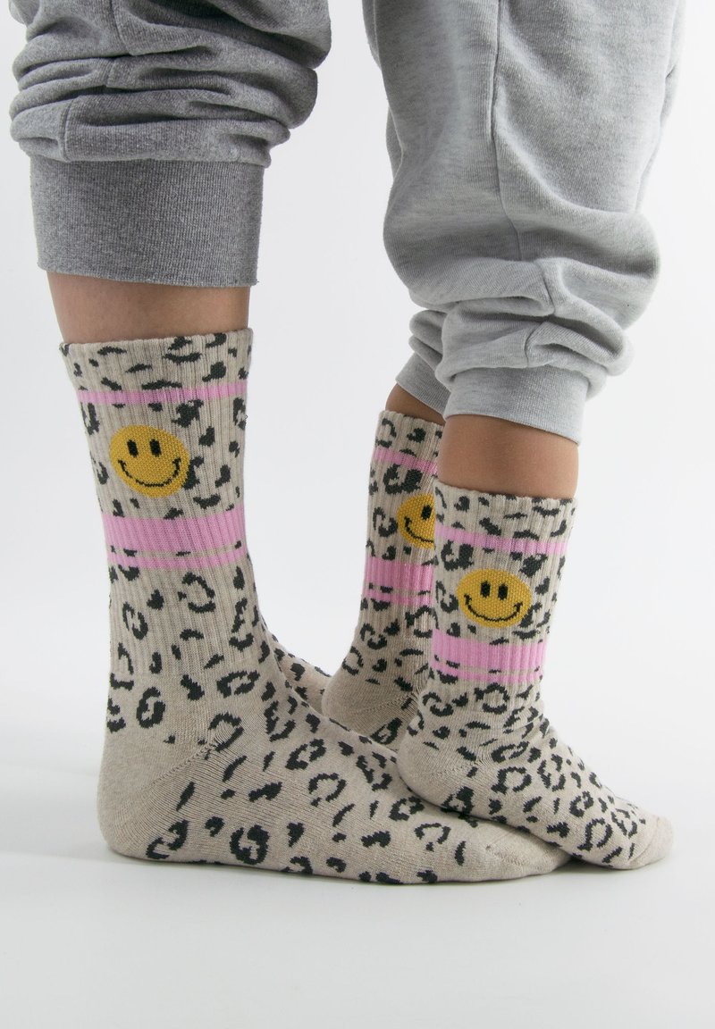 Leopardenmuster-Socken mit pinken Streifen, verziert mit gelben Smiley-Gesichtern. Hergestellt aus einem weichen, dehnbaren Stoff mit geripptem Textur.