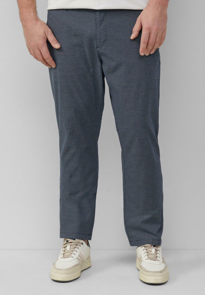 Marineblauwe geruite broek gemaakt van lichtgewicht stof, met een ontspannen pasvorm en een recht gesneden ontwerp. Gecombineerd met witte sneakers en een simpele witte shirt.