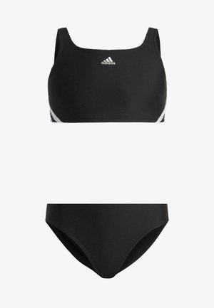 Costume da bagno a due pezzi nero con top in stile reggiseno sportivo a scollo quadrato e strisce bianche a contrasto, abbinato a slip bikini semplici.