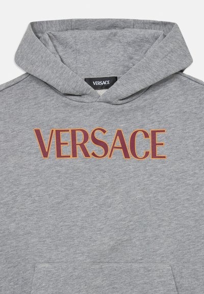 Szürke pamut kapucnis pulóver elülső zsebből és állítható kapucniból áll. Az mellkason „VERSACE” logó narancssárga és bordó nyomattal díszítve.